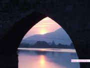 Reflejo del amanecer  bajo uno de los cinco arcos del puente romano de Petn